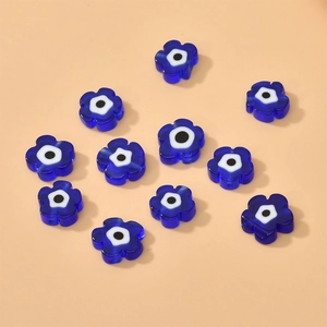 Detailed view of eleven flower-shaped blue evil eye glass beads for DIY jewelry making