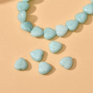 Macro view of polished heart-shaped light green natural stone beads for DIY jewelry