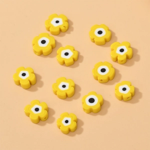 Macro shot of yellow flower-shaped millefiori beads with center dots for DIY jewelry making