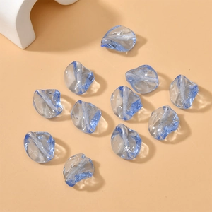 Macro detail of twisted leaf-shaped light blue glass beads for DIY jewelry making