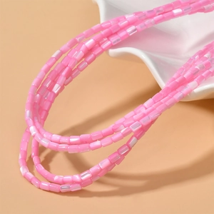 Dettaglio macro di perle di conchiglia rosa naturale a forma di tubo per gioielli fai da te