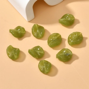 Macro shot of 9 green spiral leaf-shaped glass beads for handmade jewelry making