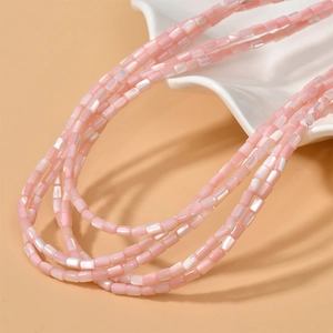 Dettaglio macro di perline cilindriche in madreperla rosa per creazione gioielli