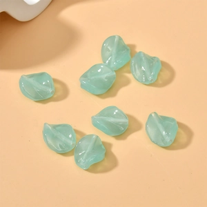 Close-up of light green translucent twisted leaf glass beads for DIY jewelry making