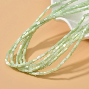 Macro dettagliata di perle cilindriche in madreperla verde chiaro con lucentezza