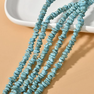 Macro-opname van turquoise onregelmatige stenen kralen voor DIY-sieraden op wit