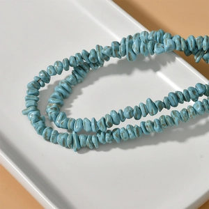 Detailopname van onregelmatige turquoise kralen met natuurlijke aders op een bord