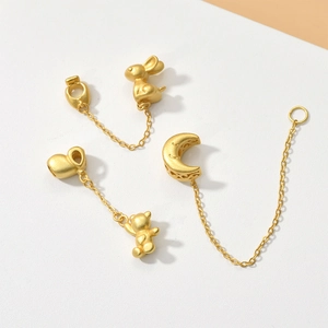 Detail view of gold matte charms featuring a bunny, bear, and crescent moon for DIY jewelry