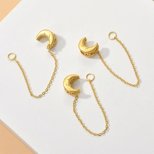 Detailed view of gold moon charms with hollow design and chain rings for jewelry making