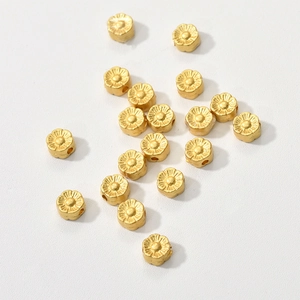 Macro shot of matte gold flower-shaped spacer beads for DIY jewelry making and crafting