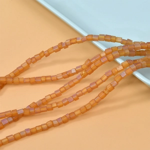Makro-Detail von 4mm matten orangefarbenen quadratischen Glasperlen für DIY-Schmuckherstellung