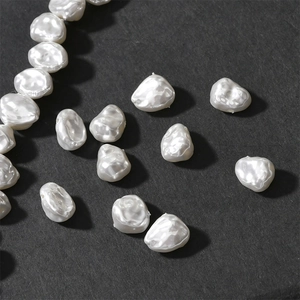 Macro shot of irregular white baroque pearl beads for vintage DIY jewelry on black background
