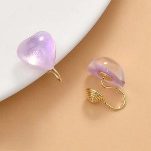 Detail of purple heart-shaped resin clip-on earrings with 14k gold spiral ear clips