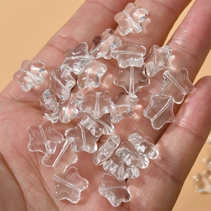 Detailed view of 12mm clear frosted star-shaped glass beads held in hand for DIY jewelry