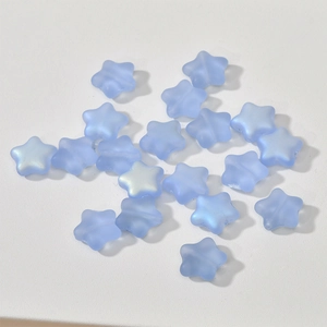 Macro detail of 12mm light blue frosted star-shaped Czech glass beads for DIY jewelry