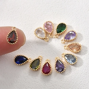 Macro view of colorful teardrop zircon charms with 14k gold plated beaded edges for DIY