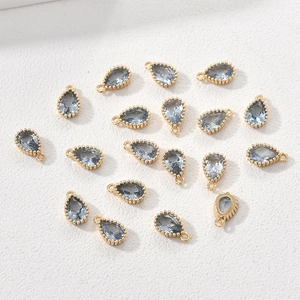 Detailed view of 14k gold-plated teardrop charms with light blue zircon for DIY jewelry