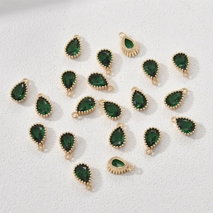 Detail of 14k gold plated teardrop pendants with green zircon for jewelry making