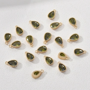 Close-up of olive green pear-shaped zircon pendants with 14k gold-plated beaded borders
