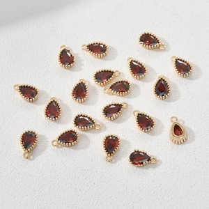 Macro view of teardrop red zircon pendants with 14k gold plated copper for DIY jewelry