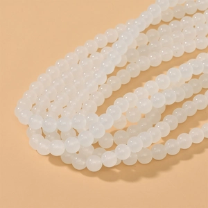 Detailed macro view of 8mm round translucent white glass beads for DIY jewelry making
