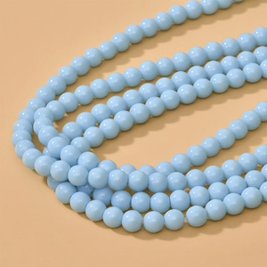 Macro view of 8mm light blue round glass beads for DIY jewelry making and necklace crafts
