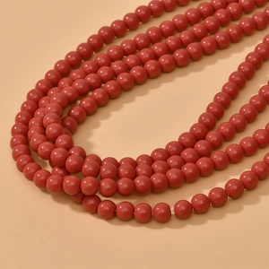 Close-up of 8mm round red glass beads with a glossy finish for DIY jewelry making