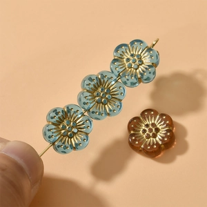 Nahaufnahme von 12mm Blumen-Acrylperlen mit Goldrand und strukturierter Metallmitte