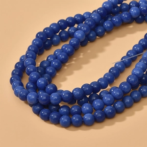 Macro detail of 8mm deep blue round glass beads with cat eye luster for DIY jewelry