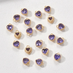 Macro-opname van 14k vergulde hartjeshangers met paarse geboortestenen voor DIY-sieraden