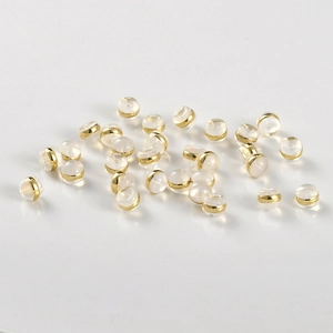 Macro detail of 18k gold-plated metal rings inside clear silicone earring backs for DIY jewelry