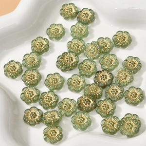 Makro-Detail von 12mm grünen Acryl-Blumenperlen mit Goldakzenten für DIY-Schmuck