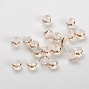 Macro detail of 18k gold-plated metal and clear silicone round earring backings for DIY