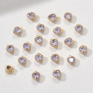 Macro-opname van 14k gouden hartvormige hangers met lavendelkleurige zirkonia steen