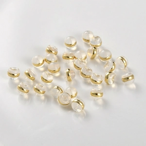 Macro view of clear silicone and 18k gold-plated ear backings for earring making