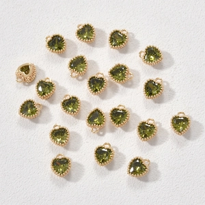 Detail van olijfgroene edelsteen hartbedeltjes in goudlook voor DIY-sieraden maken