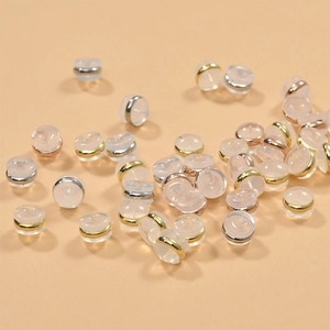 Macro detail of bulk 18k gold-plated silicone earring backings in gold, silver, and rose gold