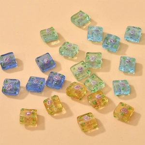 Macro shot of square floral glass beads with colorful spiral patterns for DIY jewelry making