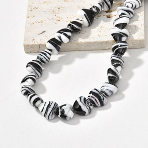 Detailed view of heart-shaped glass beads with black and white marble swirl texture