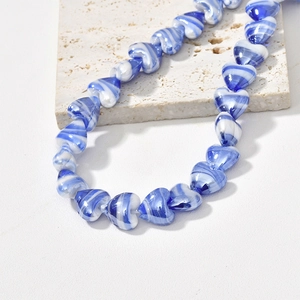 Macro shot of heart-shaped marbled glass beads with blue and white swirl textures