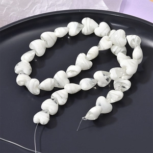 Detail of heart-shaped marble glaze beads with green tint for DIY jewelry making