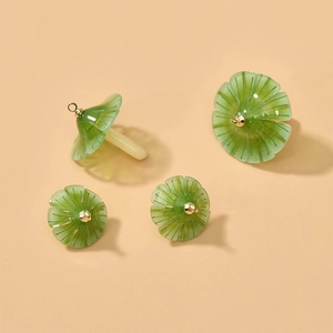 Detail of green umbrella-shaped acrylic mushroom charms with fine linear textures