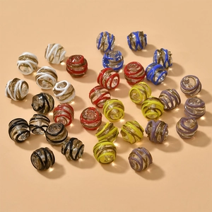 Close-up of 13mm colorful spiral glass beads with sparkling gold glitter for DIY jewelry