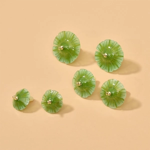 Close-up of translucent green flower charms with textured petals and golden centers