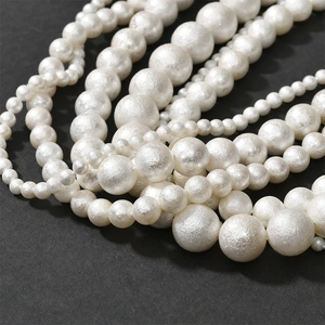 Macro shot of layered cream faux cotton pearls with matte texture on black background
