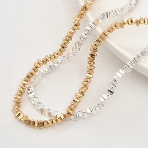 Macro detail of irregular gold and silver geometric beads for DIY jewelry making