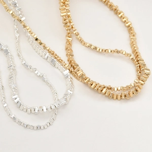 Close-up of irregular triangular gold and silver metal beads for DIY jewelry making