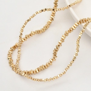 Detailed close-up of golden irregular geometric beads for DIY jewelry making material