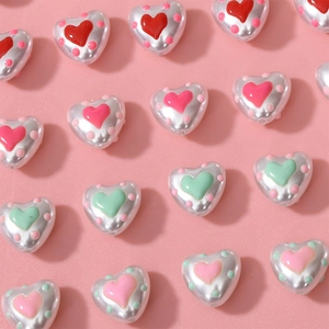 Macro shot of pearlized heart-shaped beads with colorful polka dots for DIY jewelry