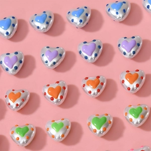 Detailed view of heart-shaped pearlized beads with colorful dots for DIY jewelry making
